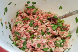Hackfleisch mit Zwiebeln, Eiern, Bärlauch usw. vermengen