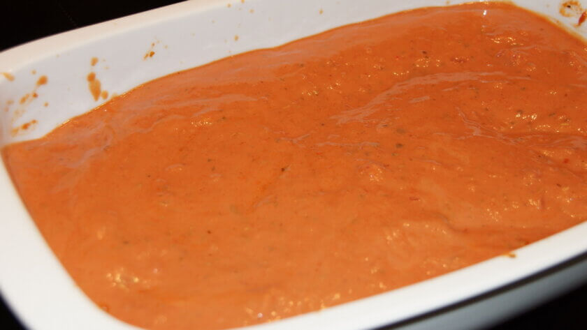 Tomatensauce und Käse über die Cannelloni geben