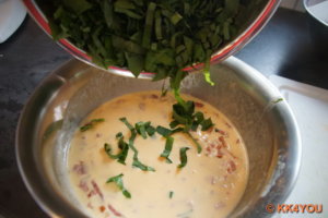 Eier mit Schlagsahne verrühren, Bärlauch mit gewürfelter Wurst mischen