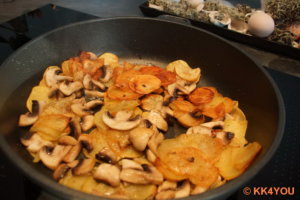Champignons in Scheiben zu den Kartoffeln dazugeben