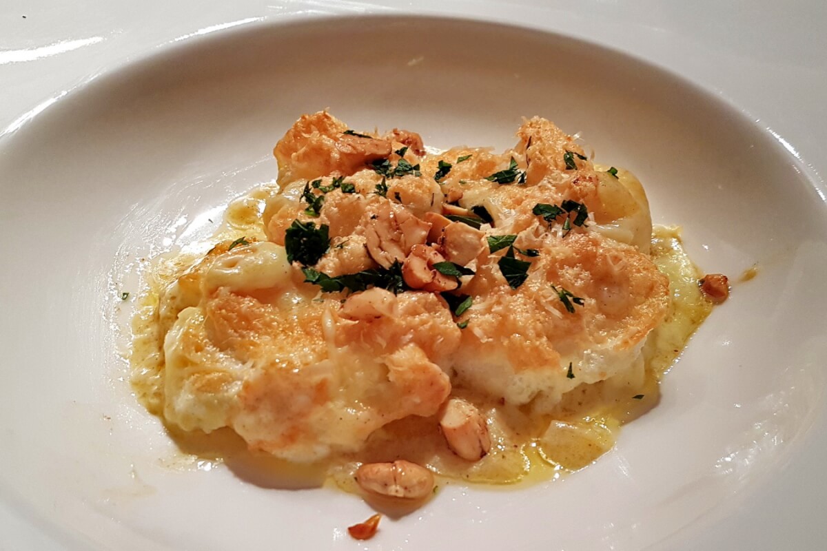 Scampi-Auflauf mit Nüssen bestreuen und servieren