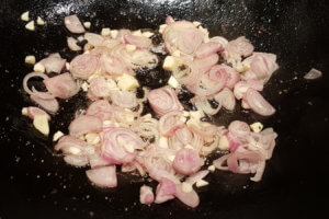 Schalotten und Knoblauch im Wok andünsten