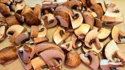Champignons putzen und in Scheiben schneiden