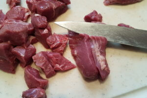 Lammfleisch in mundgerechte Stücke zerteilen