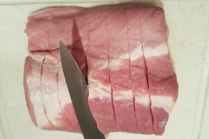 Schweinerückenbraten mit einem scharfen Messer einschneiden