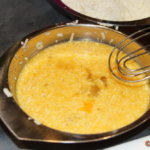 Eier und Sahne mit 50g Parmesan, Salz und Pfeffer zu einer schaumigen Masse verrühren