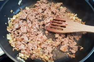 Hackfleisch zu den Zwiebeln und dem Knoblauch in die Pfanne